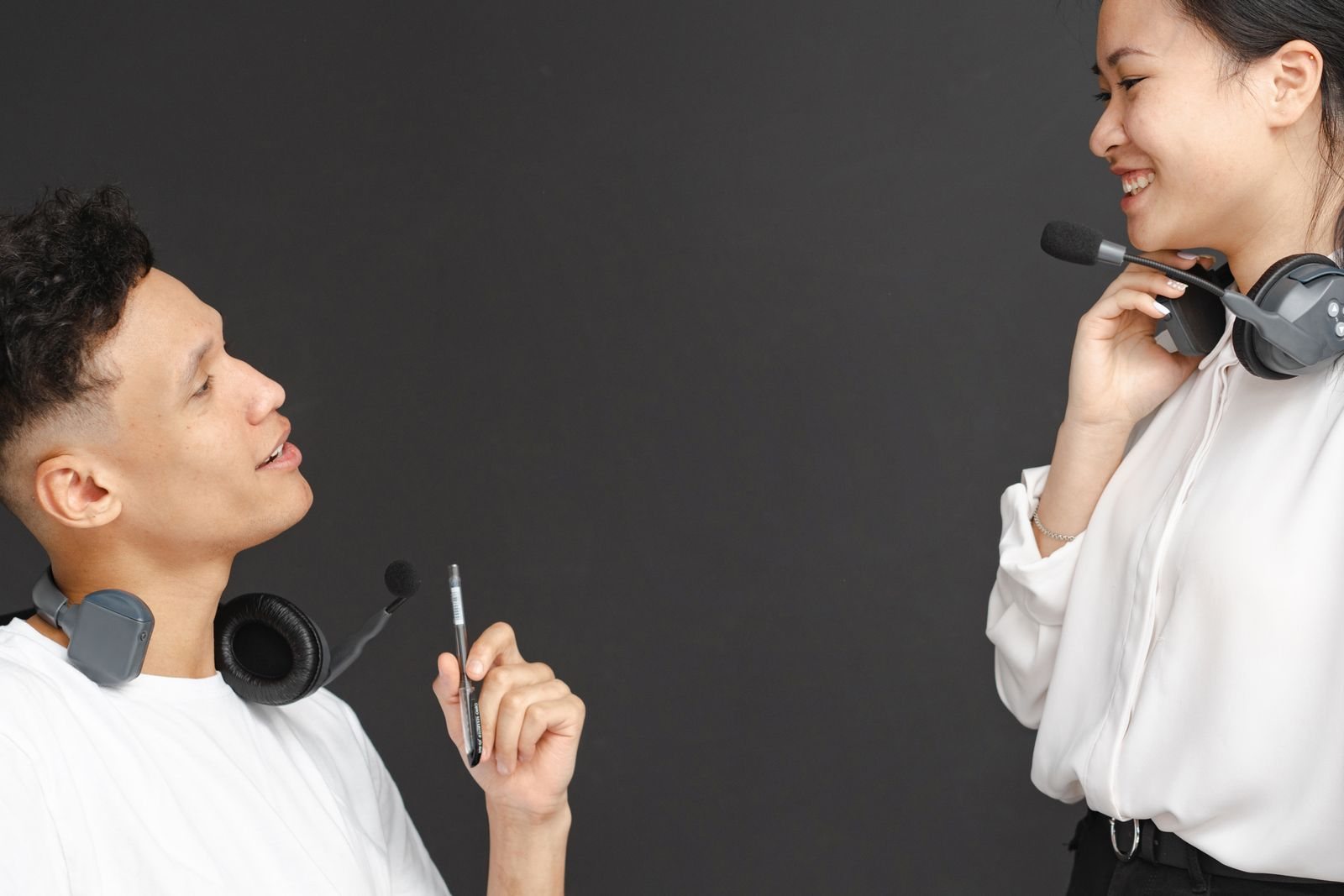 Customer support colleagues wearing headsets have a conversation.