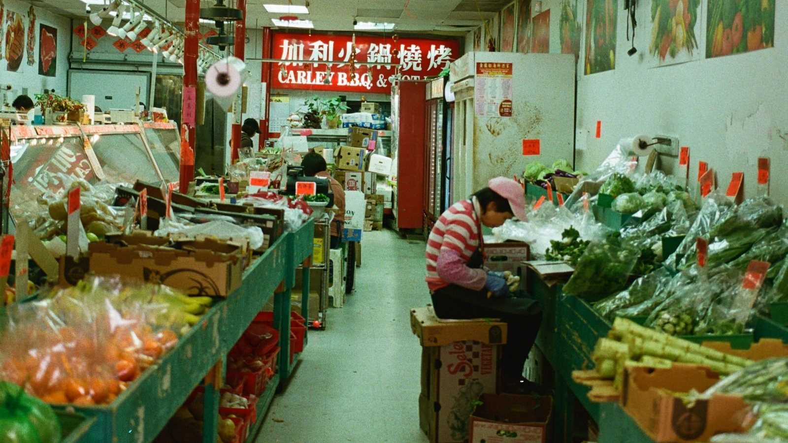 Produce displays and a vendor inside a market in Vancouver, British Columbia.