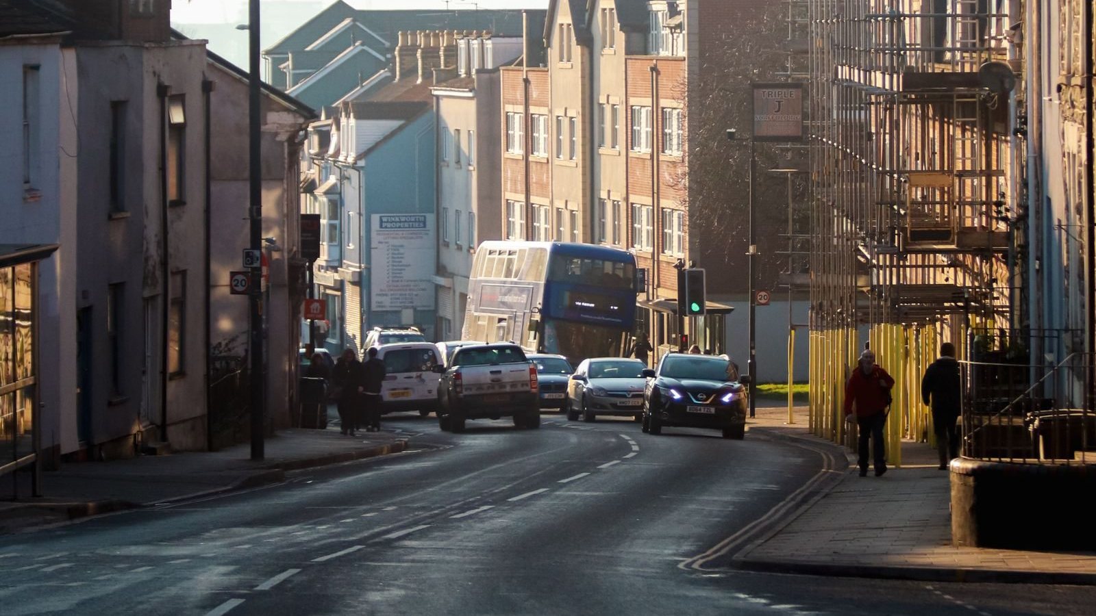 Cars and pedestrians on a city street in Bristol, England.