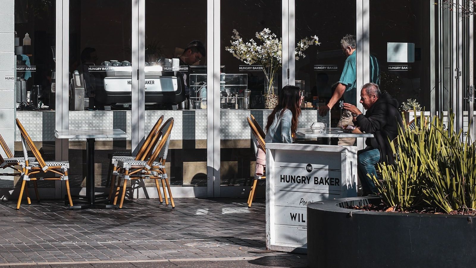 People dining outdoors at a café in Parramatta, New South Wales.