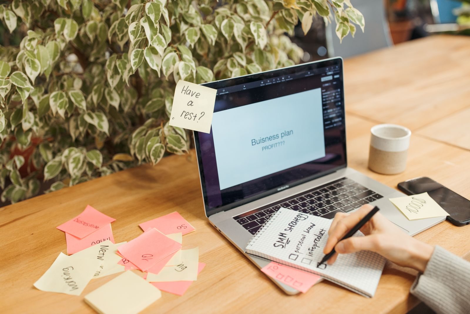 A planning workspace with sticky notes, a notebook and laptop.