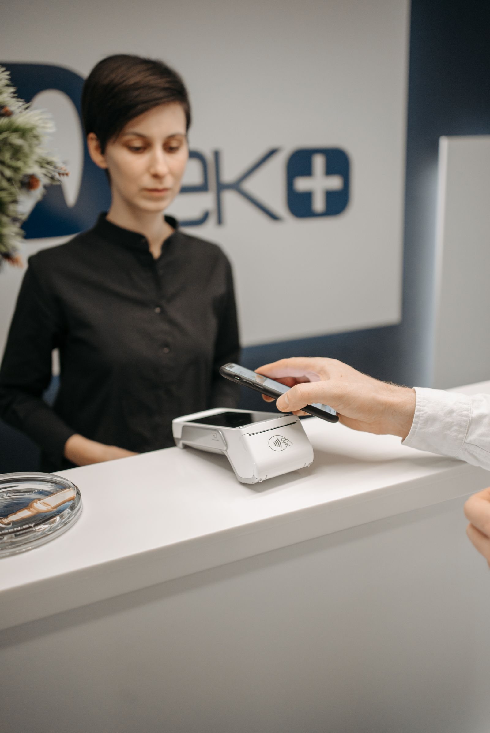 A customer uses a smartphone at a card terminal, illustrating a prepaid purchase.