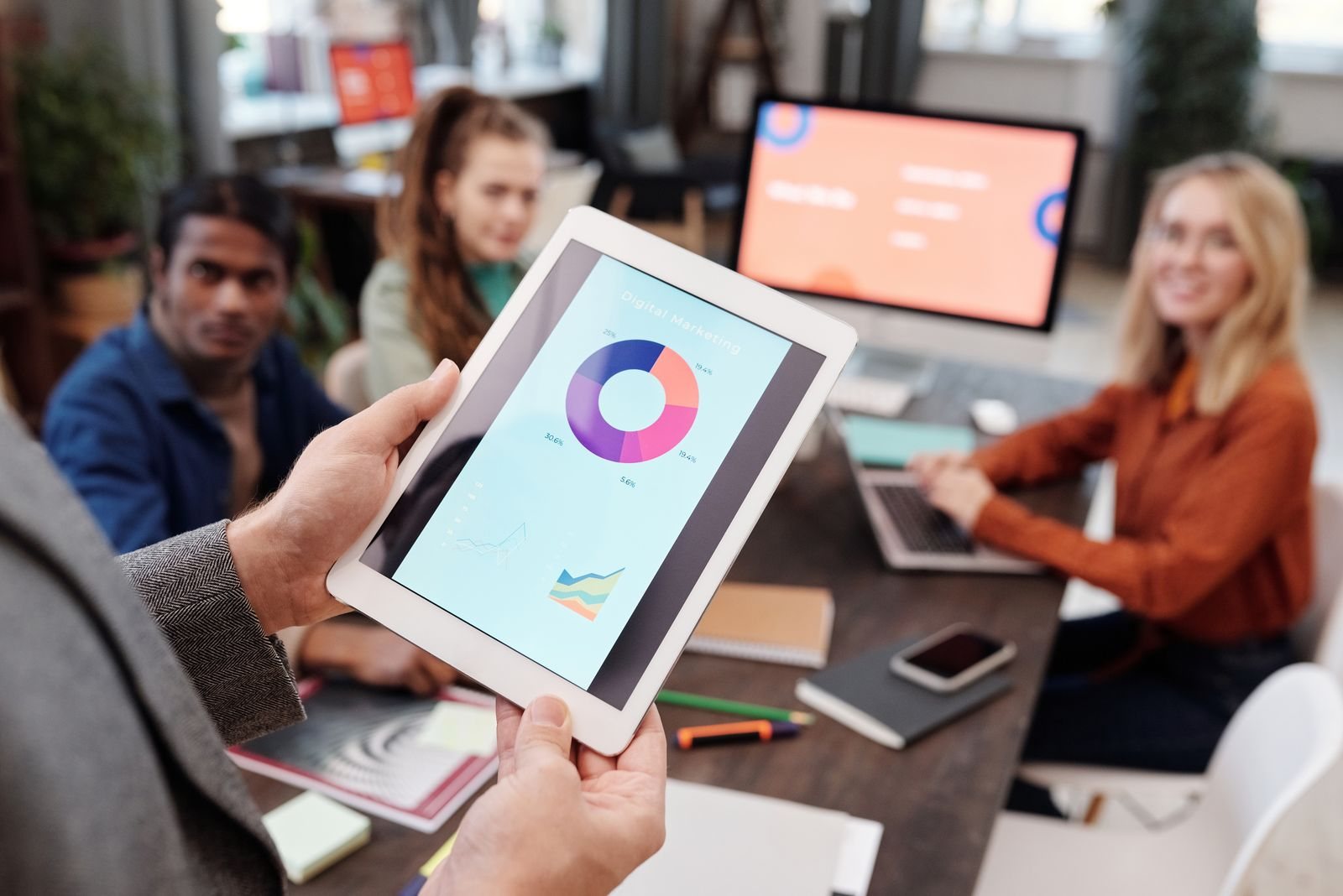 A person reviews a digital marketing chart on a tablet.