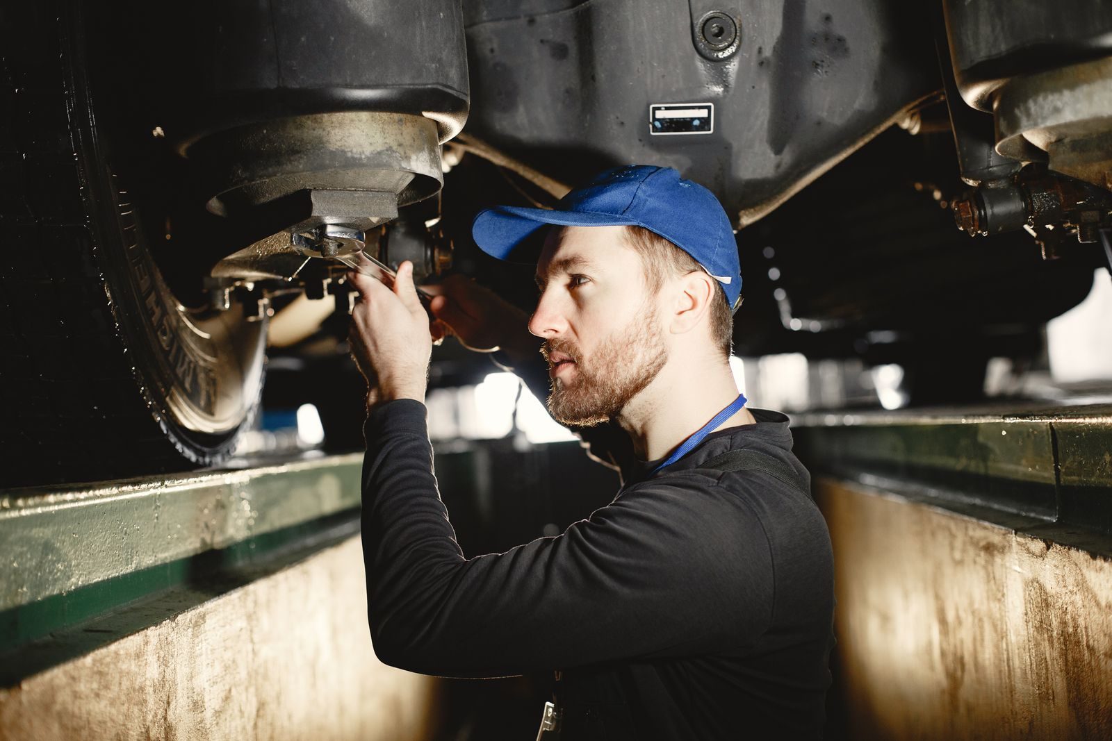 A mechanic working on a vehicle in an auto repair workshop.