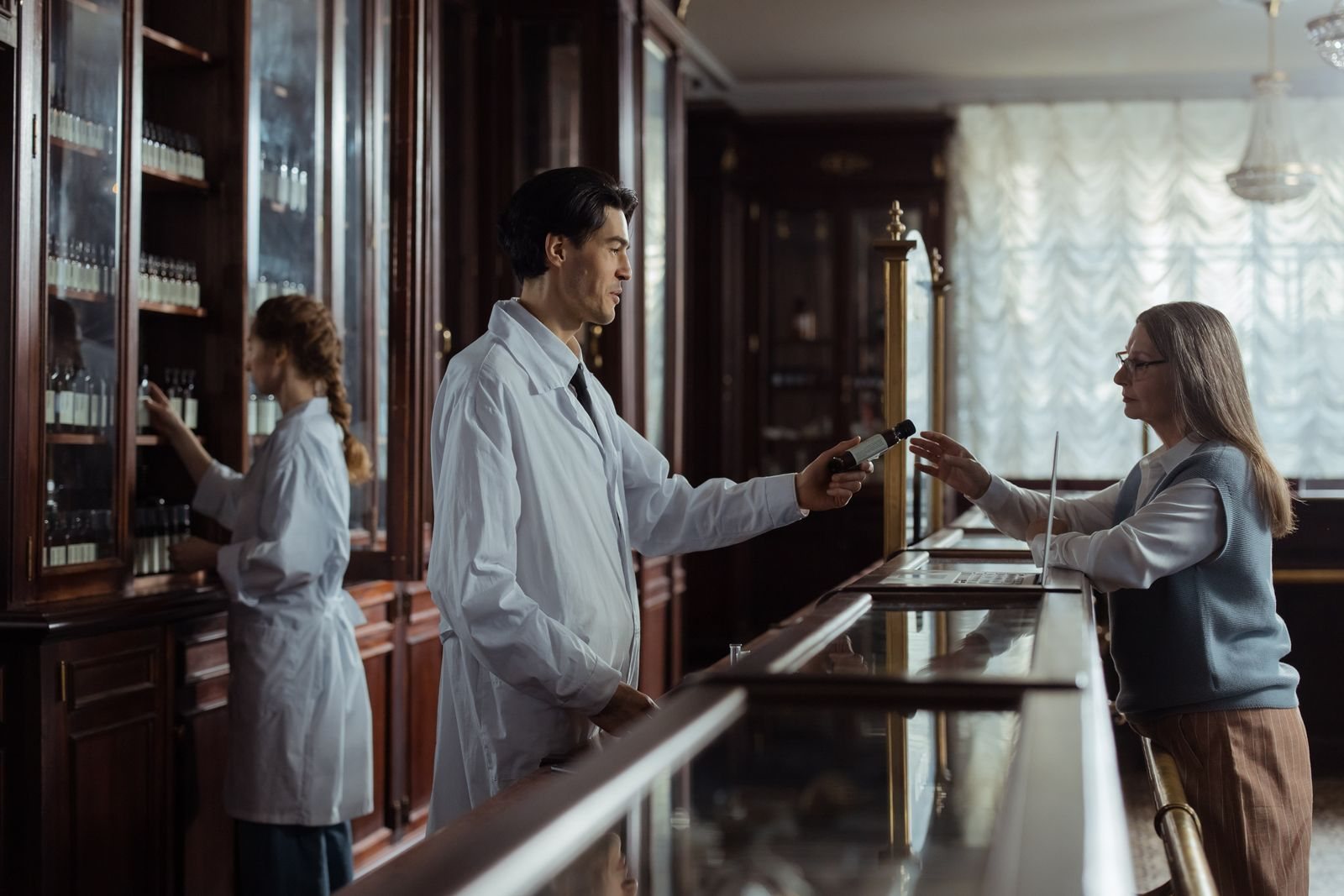 A pharmacist assisting a customer at a pharmacy counter.