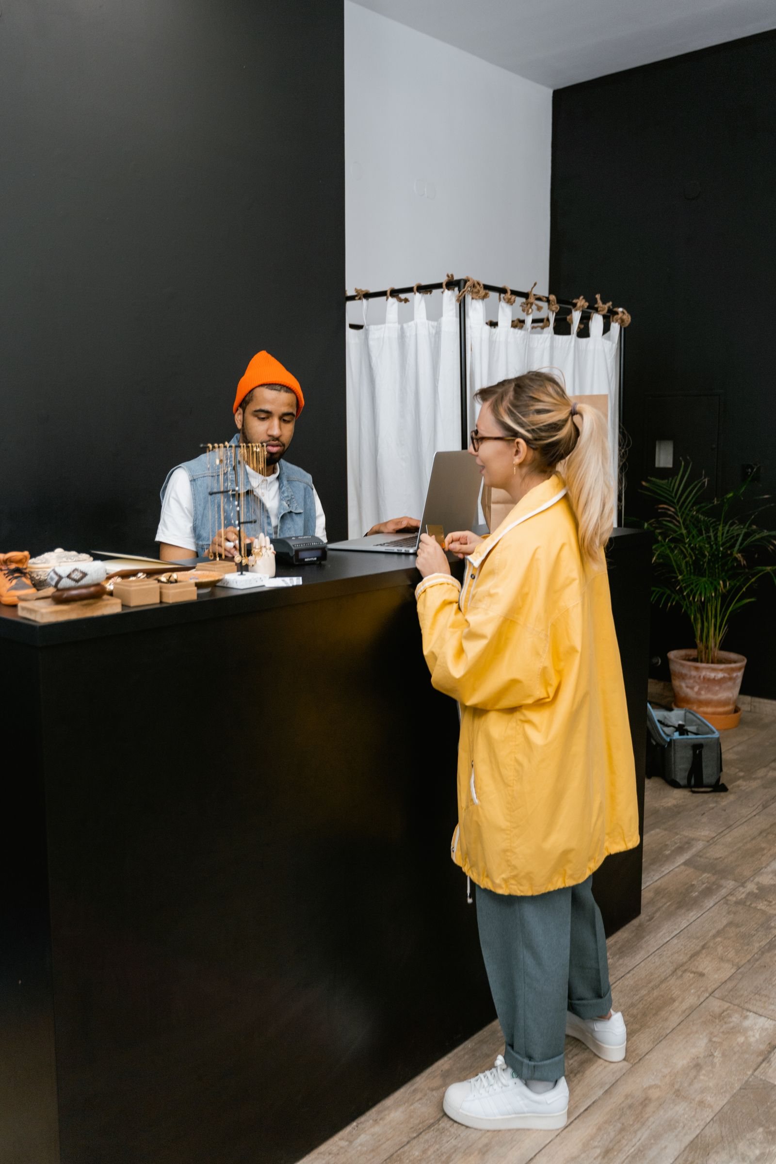 A customer making a cashless payment at a clothing store counter.